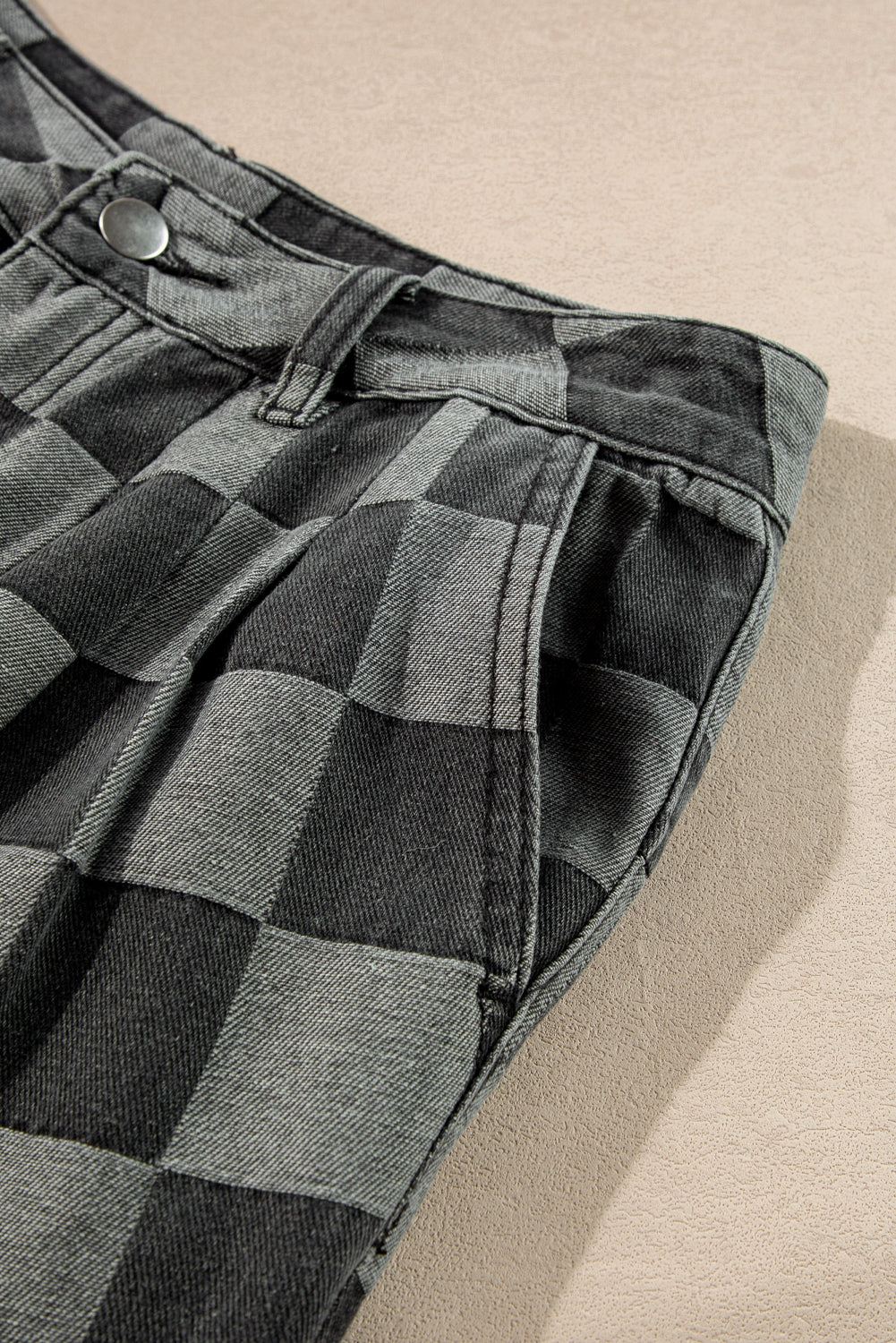Dark grey checkered wide-leg denim jeans with button detail.