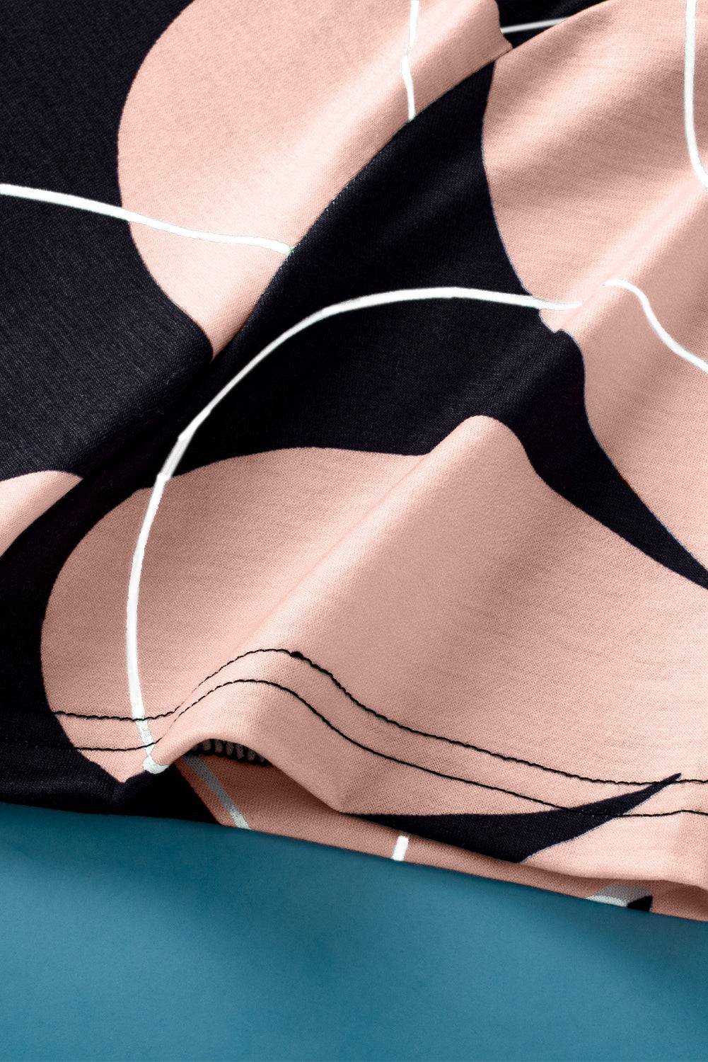 Close-up of black summer T-shirt with pink flower print and white lines, soft breathable fabric with casual round neck design.