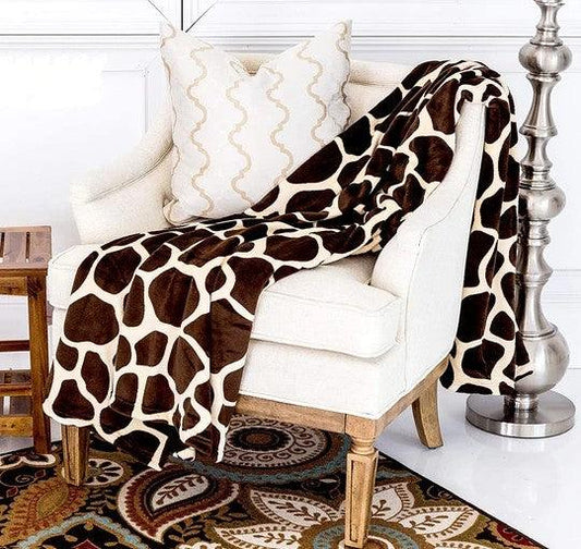 Super Soft Cozy Giraffe Flannel Blanket draped over a chair, featuring a playful giraffe print.