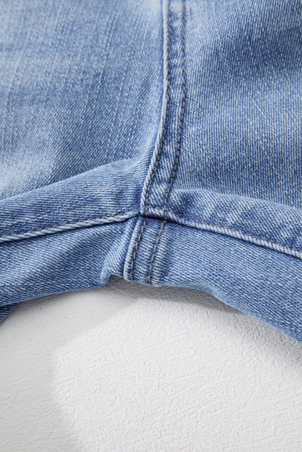 Close-up view of Beau Blue Mineral Wash jeans denim fabric and stitching.