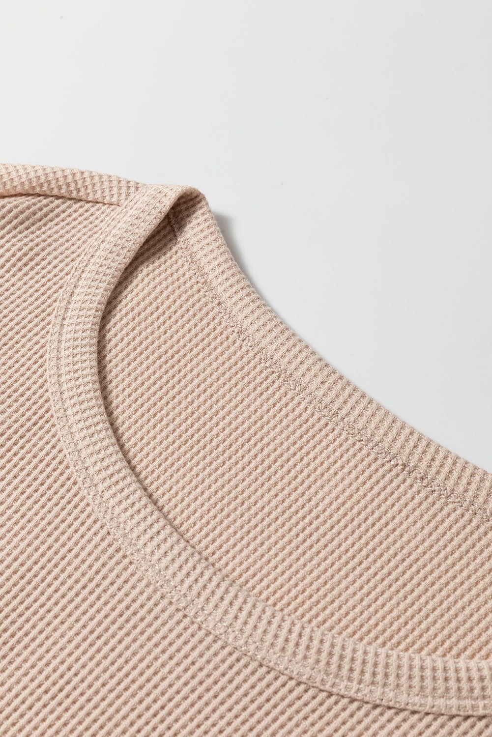 Close-up of beige Parchment Textured Lounge Set fabric on a long sleeve t-shirt neckline from a lounge set