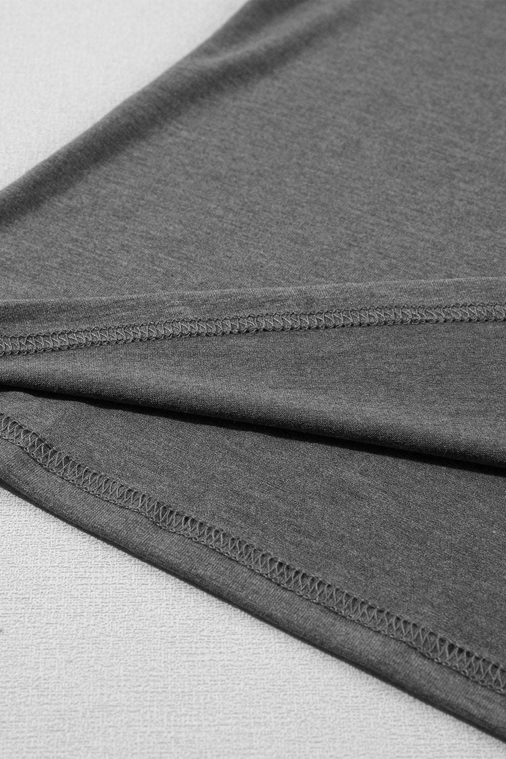 Close-up of carbon grey fabric with detailed stitching of petal sleeve V neck T shirt