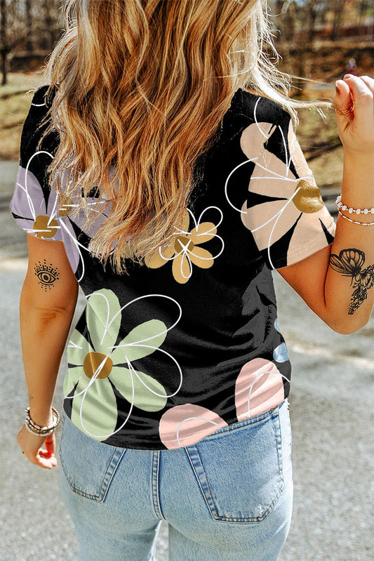 Back view of woman wearing black summer flower print casual round neck T-shirt with colorful large floral designs.