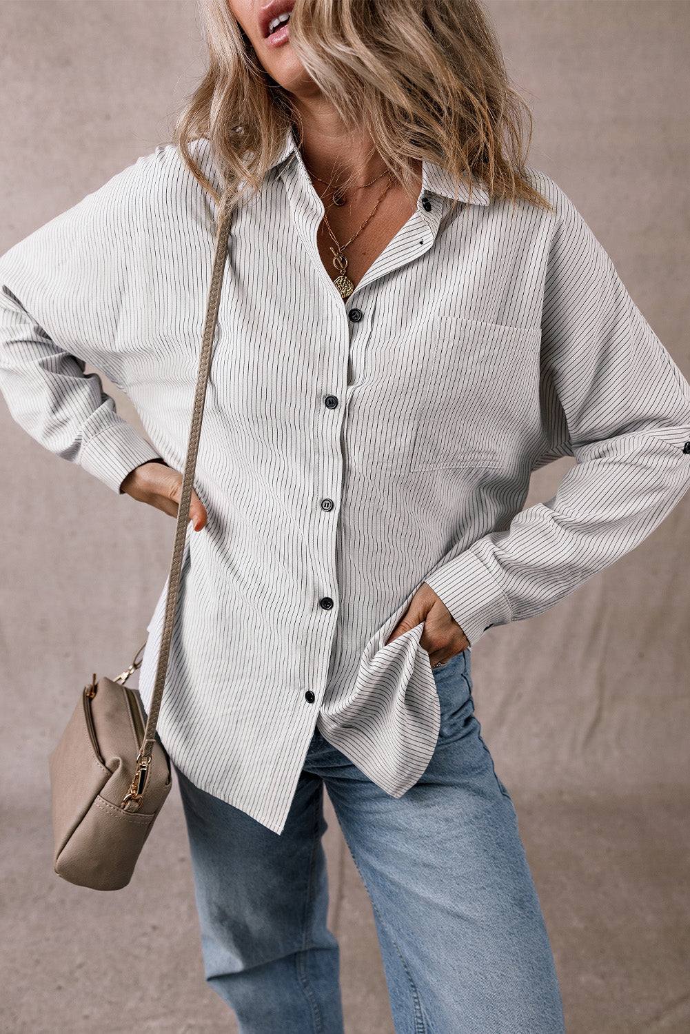 Woman wearing a DEAR-LOVER striped roll-tab sleeve pocketed long shirt with light blue jeans and a beige crossbody bag.