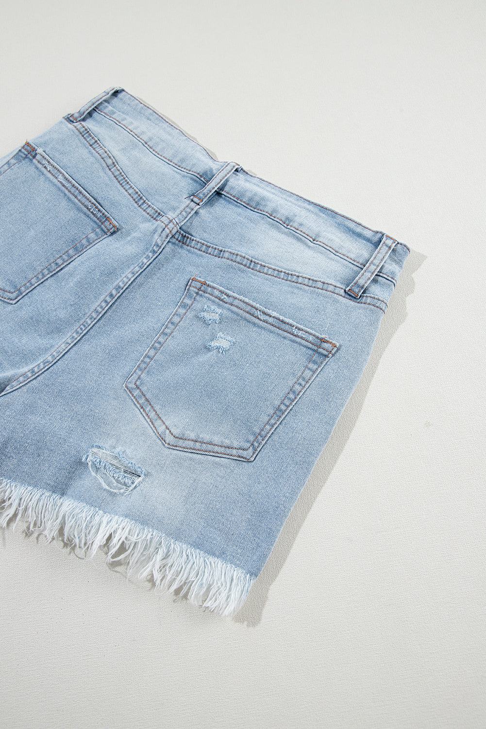Light blue distressed high waist denim shorts with ripped detailing and frayed hem.