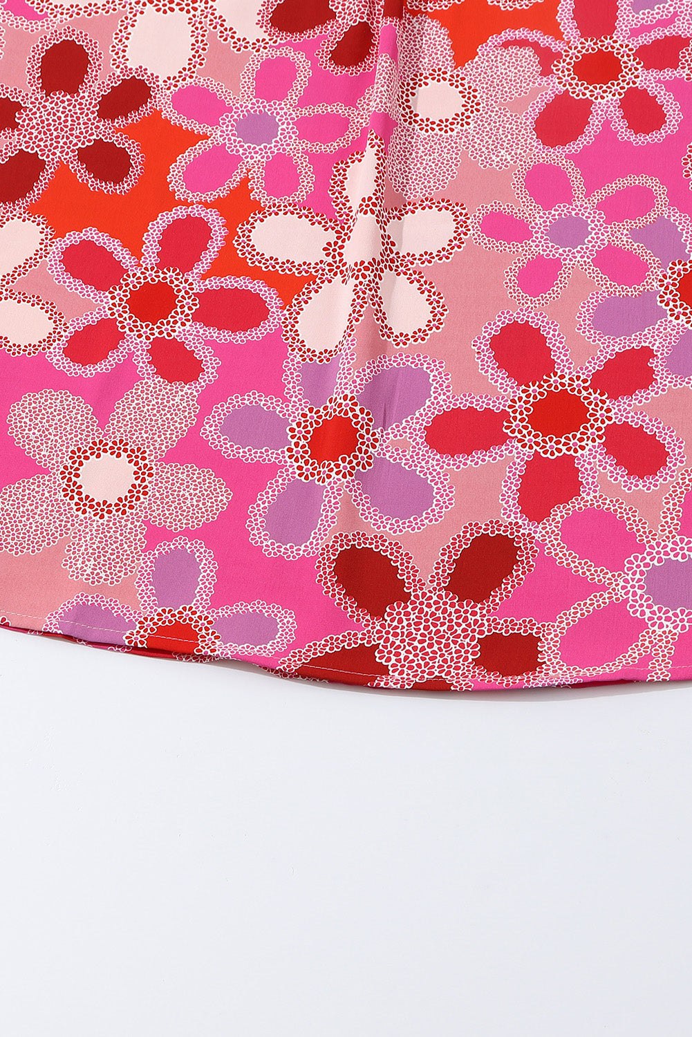 Close-up of floral pattern on the ruffled cap sleeve blouse with embroidered detail.