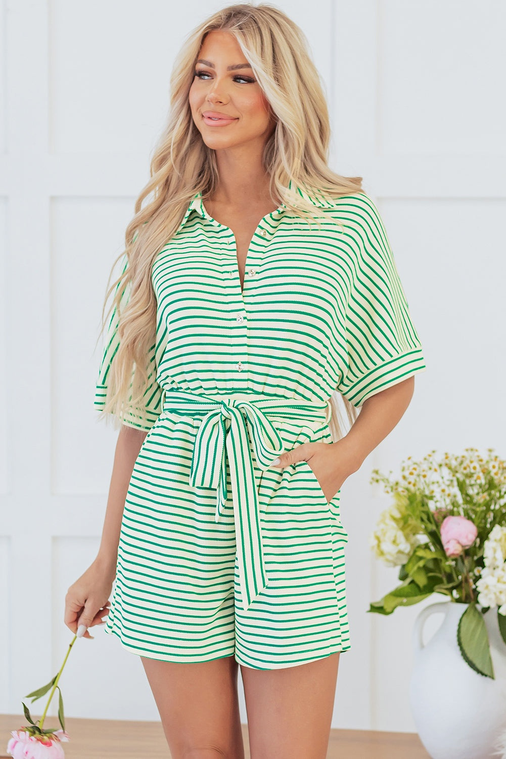 Green stripe textured short sleeve romper with collared neckline and waist tie.