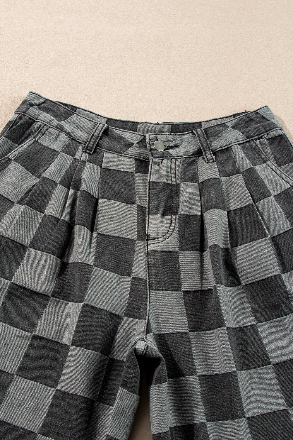 Dark grey checkered wide-leg denim jeans with button closure and pleated design.