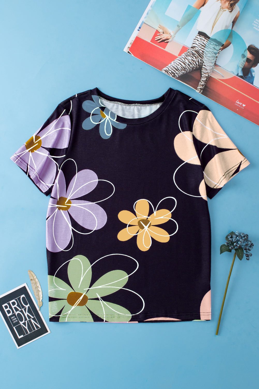 Black women's casual round neck t-shirt with vibrant summer floral print on black background