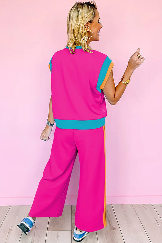 Woman wearing strawberry pink color block casual two-piece set with relaxed fit and jogger-style pants against a pink background