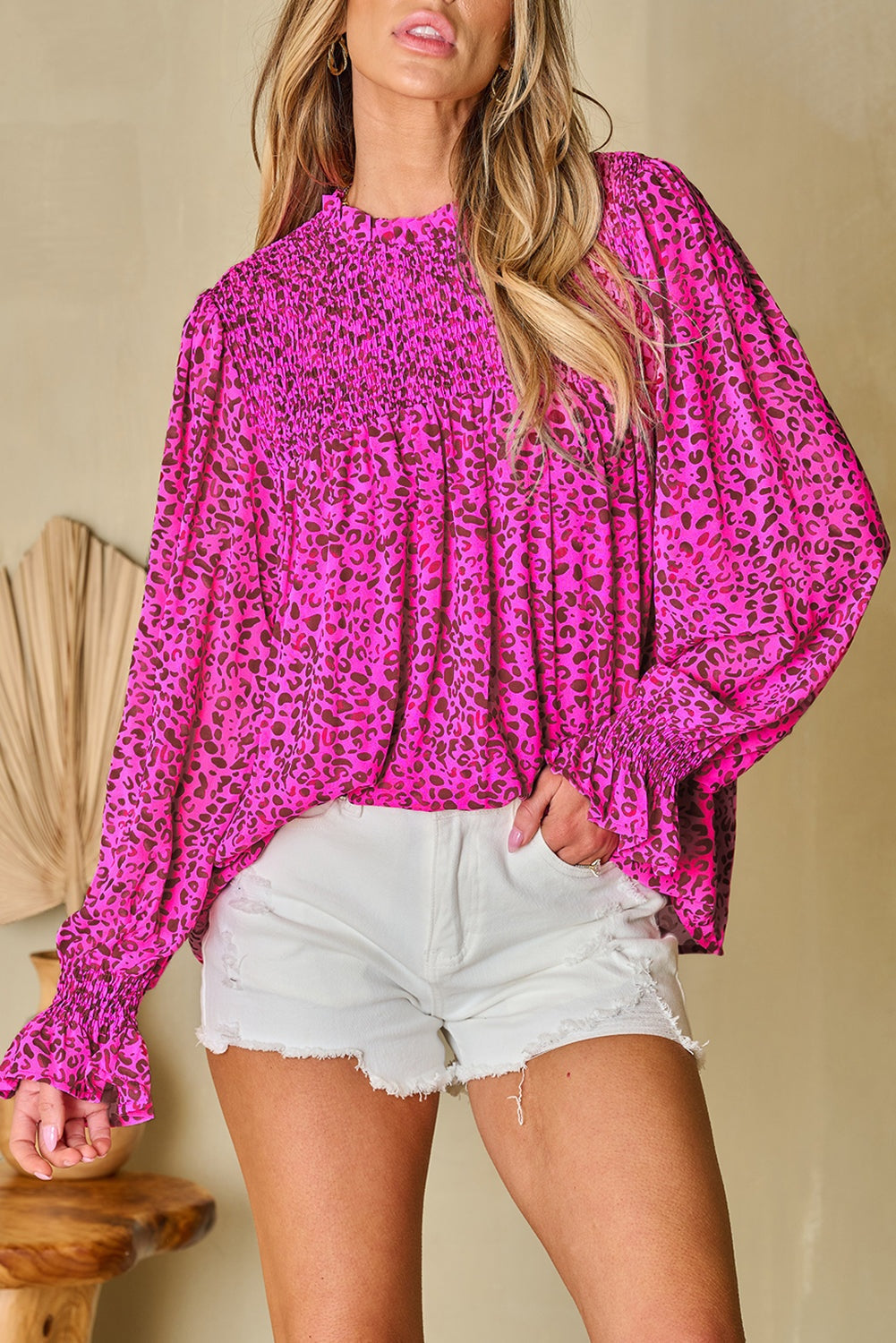 Woman wearing a leopard print Blouse with puff sleeve and shirred bodice and white shorts