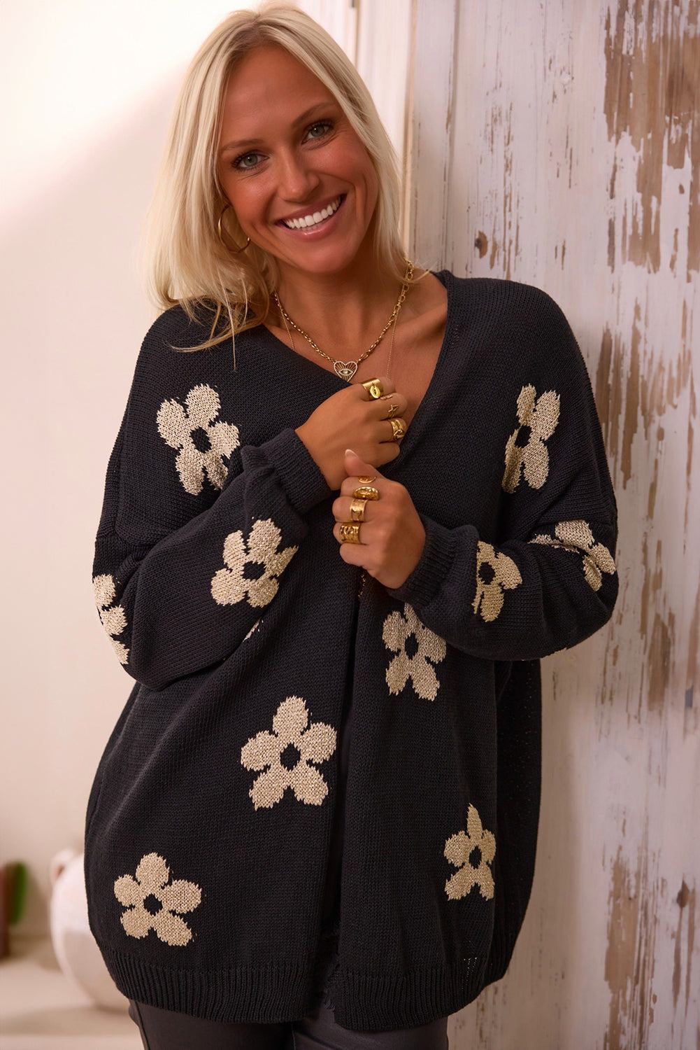 Black knitted open front cardigan with white floral print and loose fit worn by woman
