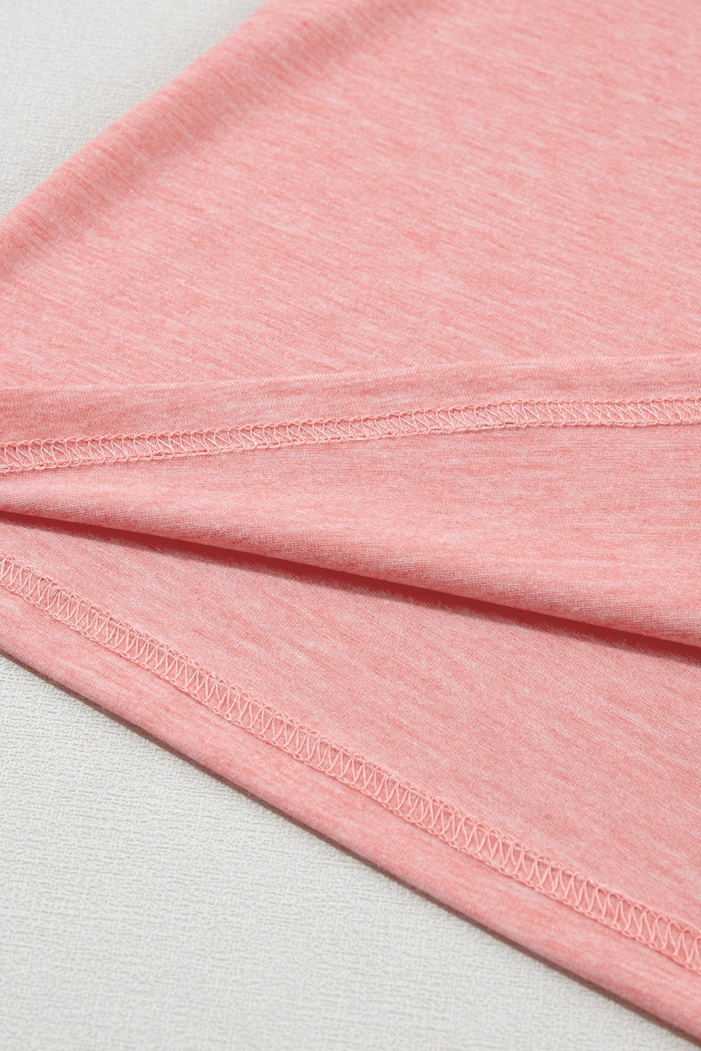 Close-up of soft rose tan fabric with petal sleeve detail from a V-neck T-shirt