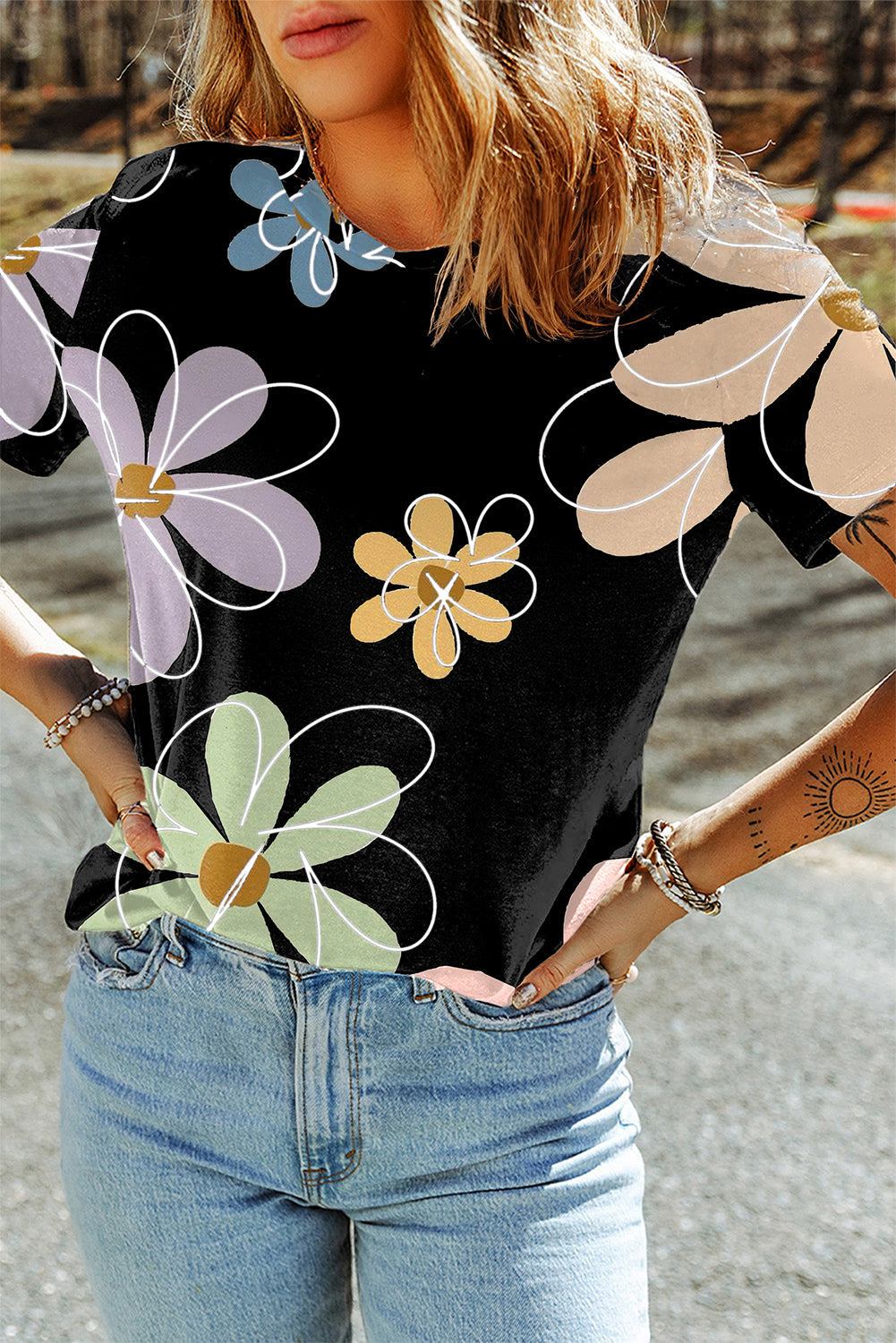 Black summer t-shirt with vibrant multicolor flower print and round neck, styled with light blue jeans