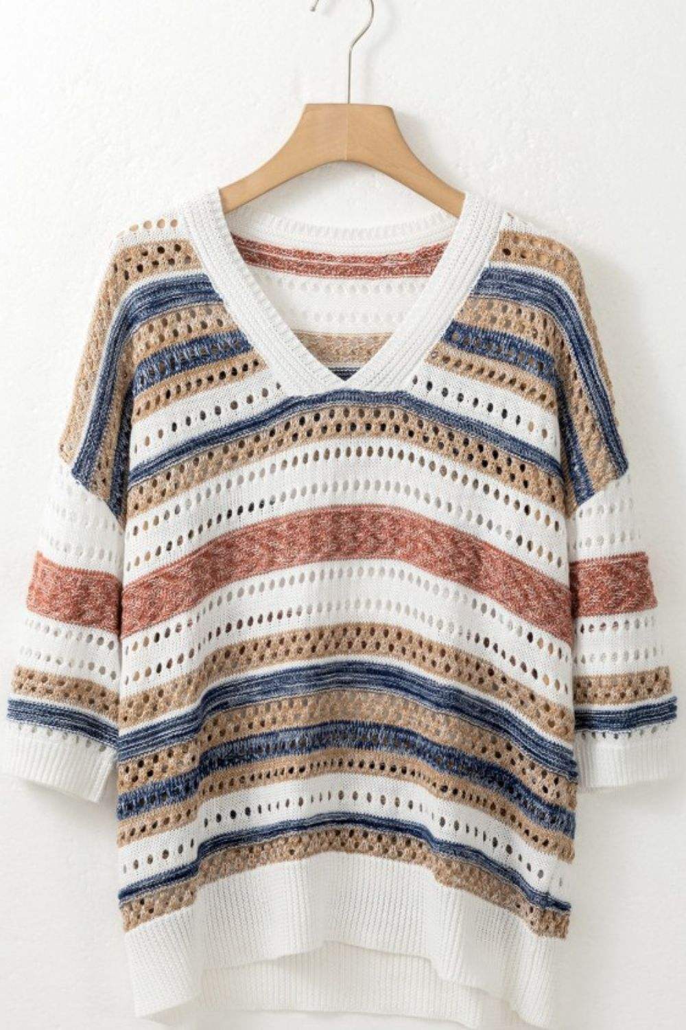 Striped knit top with hollow-out half sleeves on a hanger.