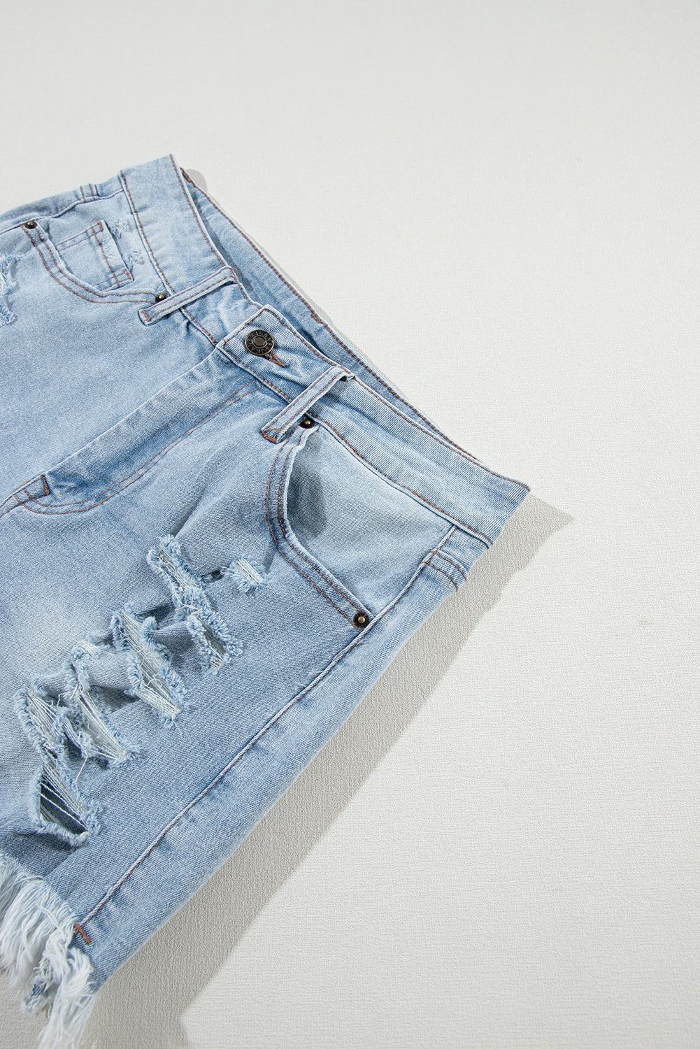 Light blue distressed high waist denim shorts with ripped detailing.