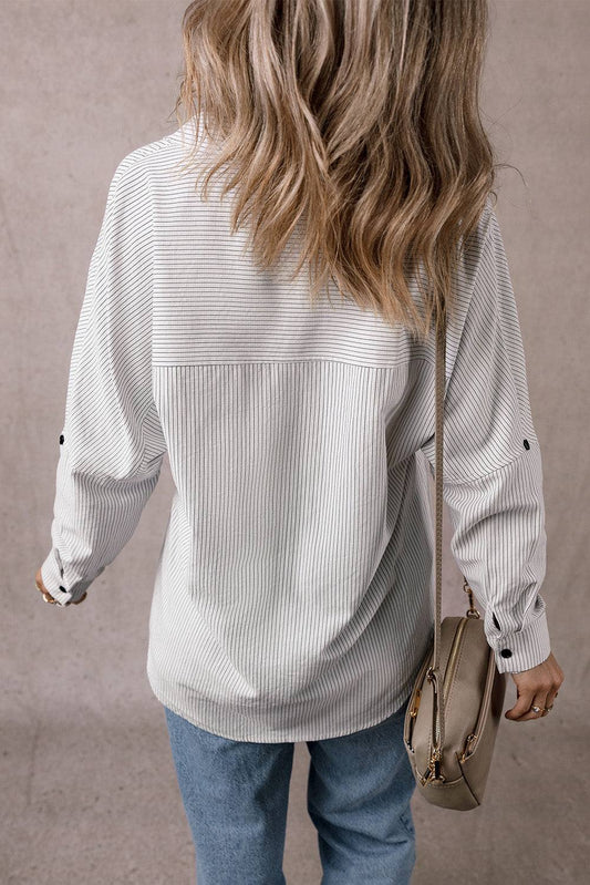 Back view of woman wearing DEAR-LOVER striped roll-tab sleeve pocketed long shirt with tunic length and casual fit