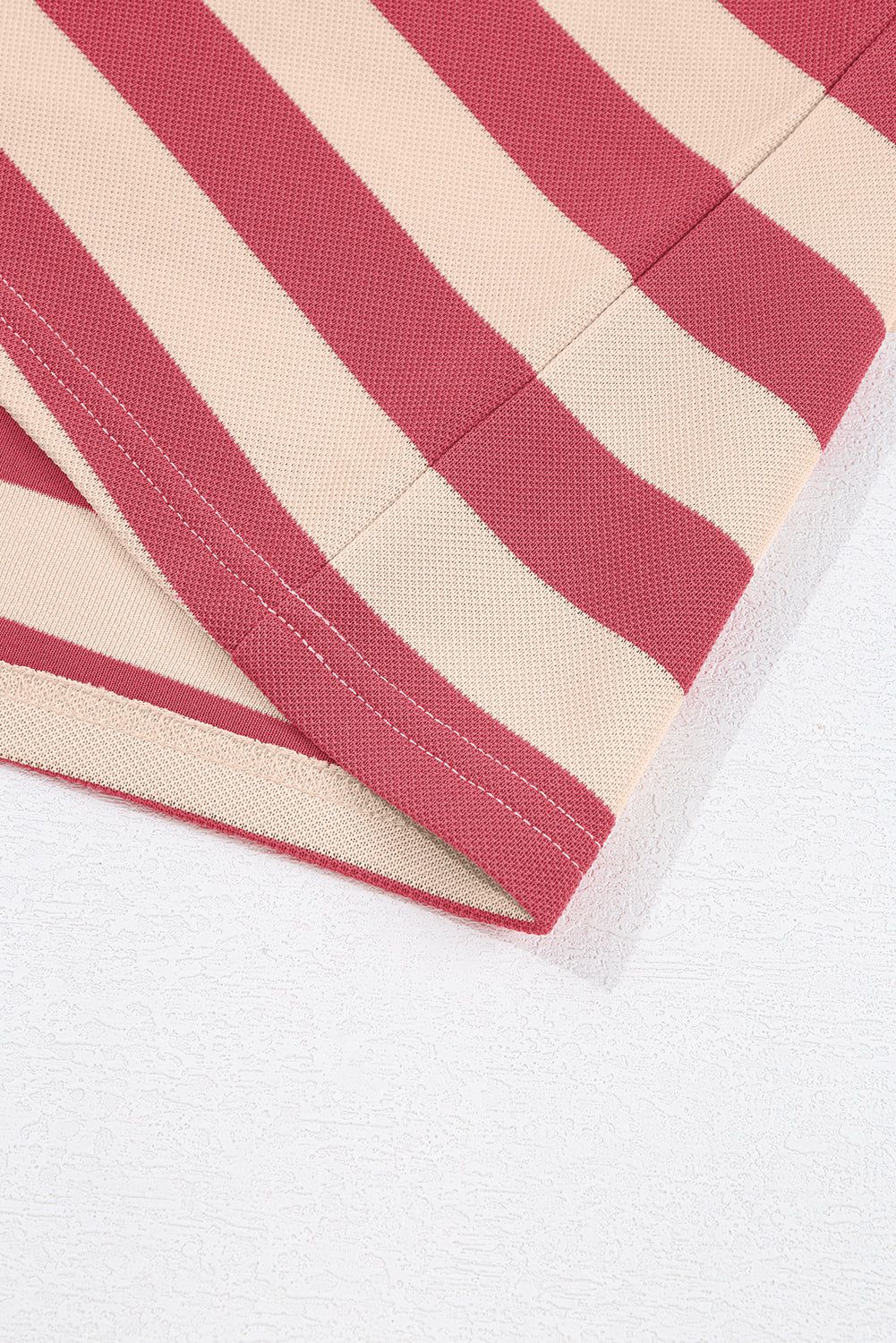 Striped mini dress fabric detail with red and beige pattern, showcasing chic elegance.
