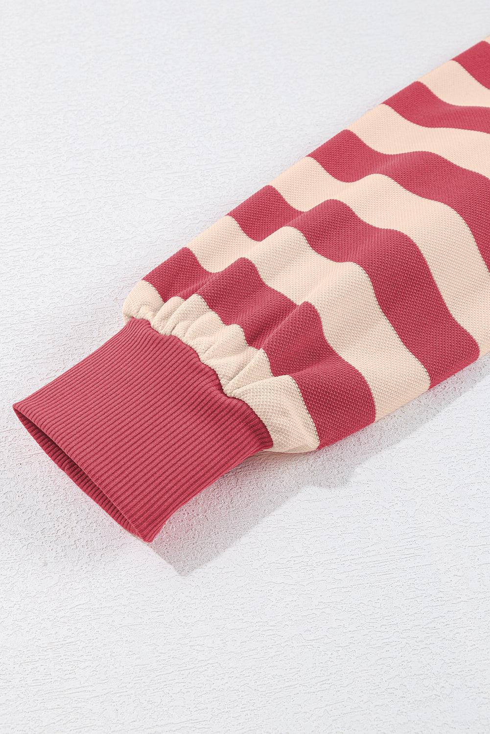 Long sleeve of a red and beige striped mini dress with elastic cuff.