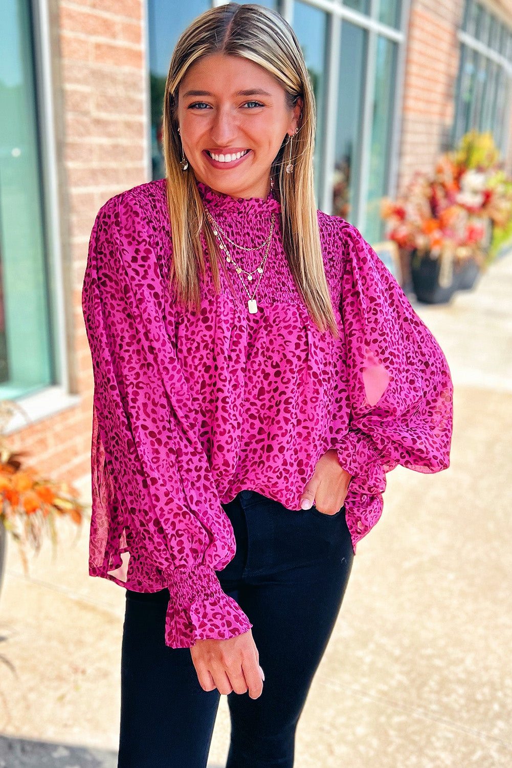 Woman wearing a bold rose leopard puff sleeve blouLeopard Print Blouse – Rose Puff Sleeve Shirred Top stylish