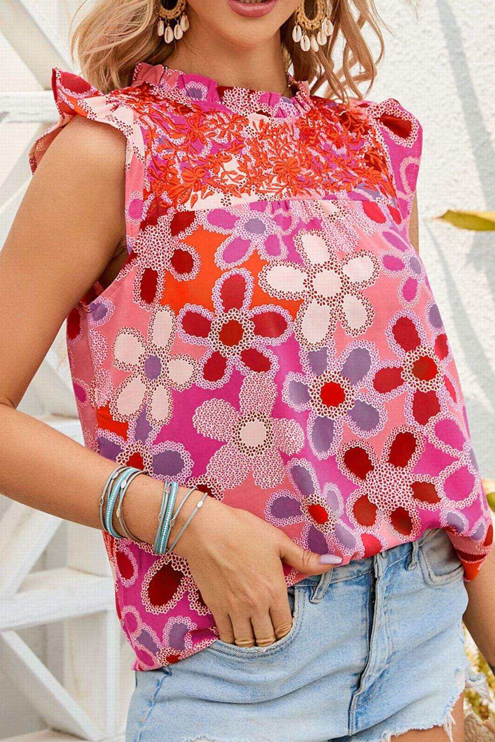 Floral ruffled cap sleeve blouse with embroidered detail, vibrant floral pattern, feminine fashion.