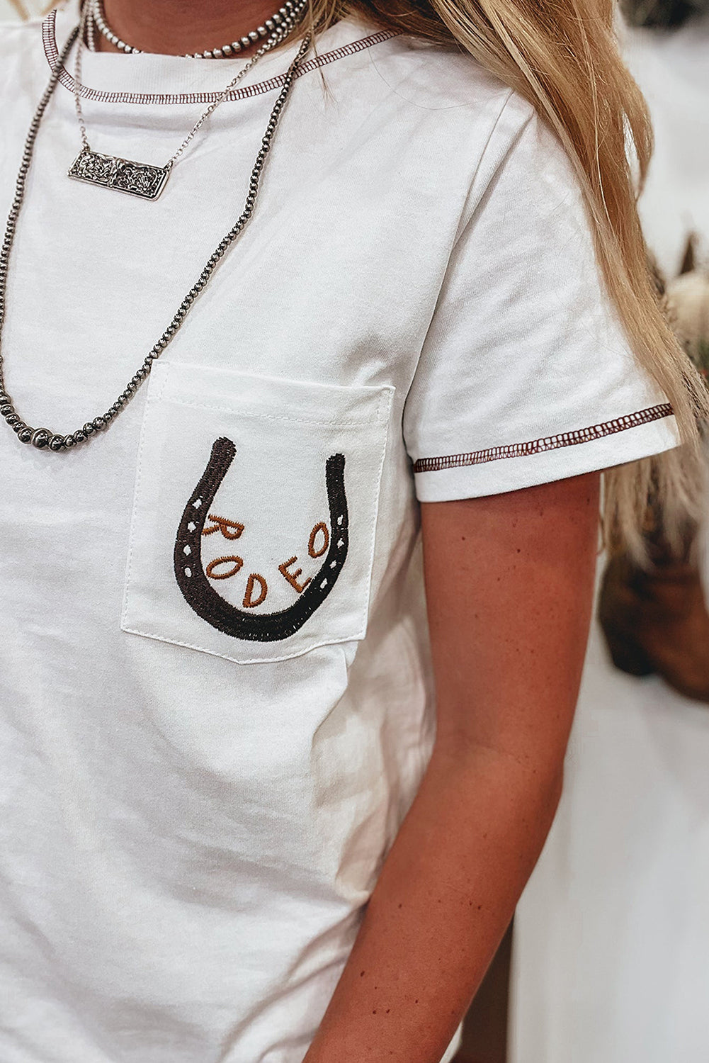 T-shirt blanc brodé fer à cheval RODEO avec poche plaquée : le charme western rencontre la fraîcheur du quotidien