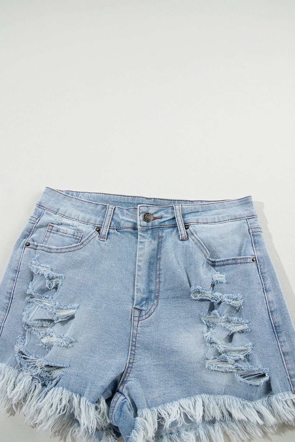 Light blue distressed high waist denim shorts with ripped detailing and raw hem.