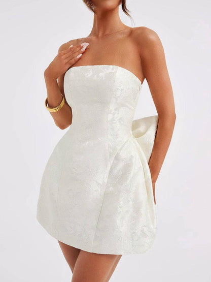 Lace-up sleeveless satin mini dress with bow in ivory, featuring a strapless design.