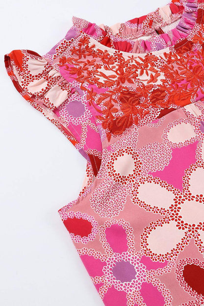 Floral ruffled cap sleeve blouse with embroidered detail and pink-red floral pattern.