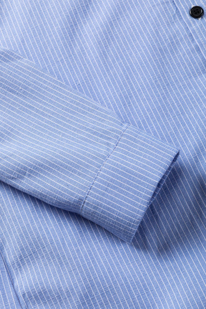 Sky blue long shirt with white stripes, roll-tab sleeve, and chest pocket close-up.