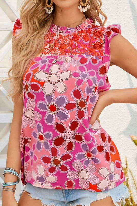 Floral ruffled cap sleeve blouse with embroidered detail, featuring vibrant floral patterns and lightweight fabric.