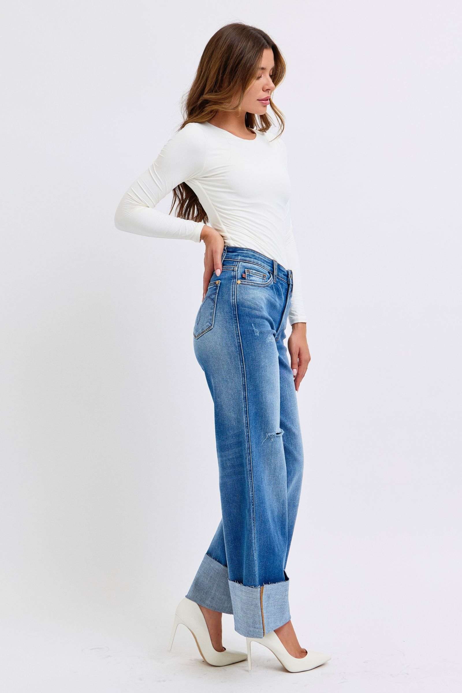 Judy Blue distressed high waist wide leg jeans worn by model in white top and heels.