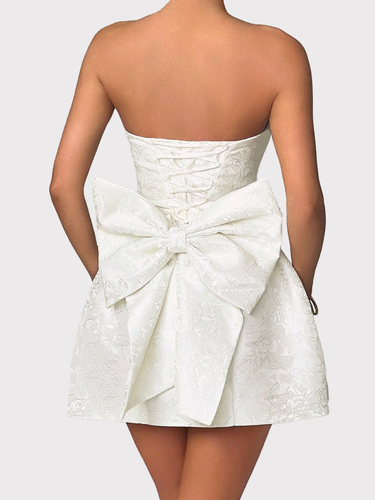 Lace-up sleeveless satin mini dress with bow detail.