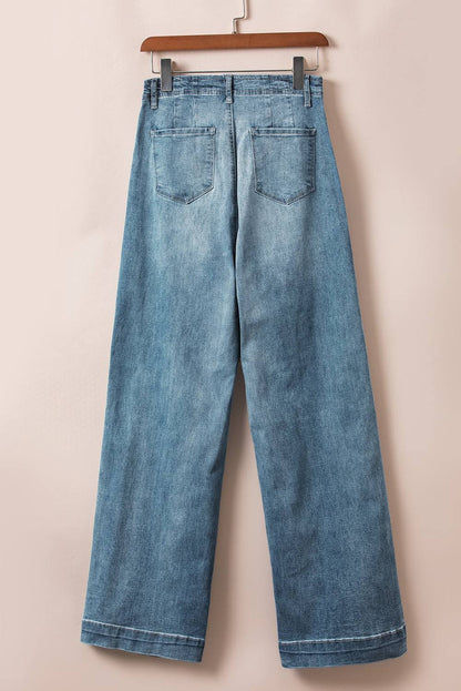 Dusk Blue medium wash straight loose leg jeans with unique multi-button design hanging on a wooden hanger.