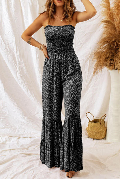 black floral jumpsuit with thin straps, smocked bodice, and wide-leg design