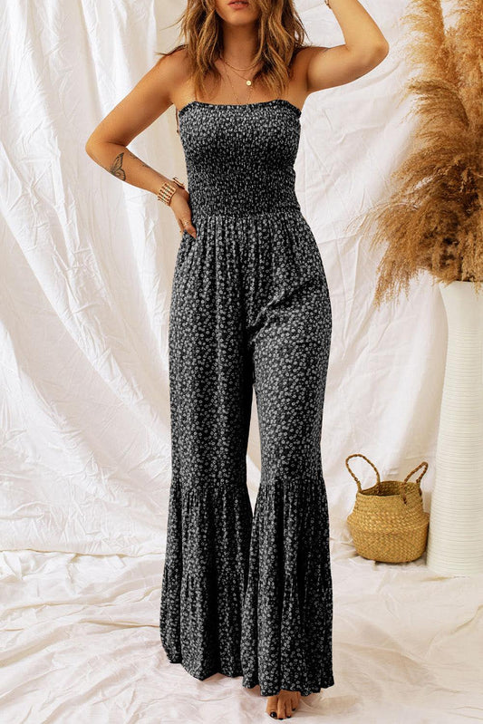 black floral jumpsuit with thin straps, smocked bodice, and wide-leg design