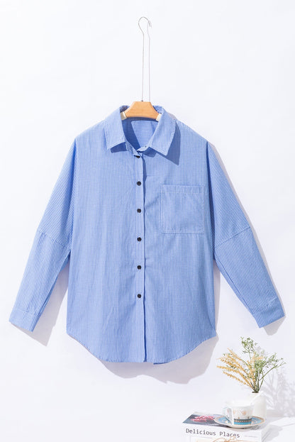 Sky blue striped long shirt with roll-tab sleeves and chest pocket on hanger